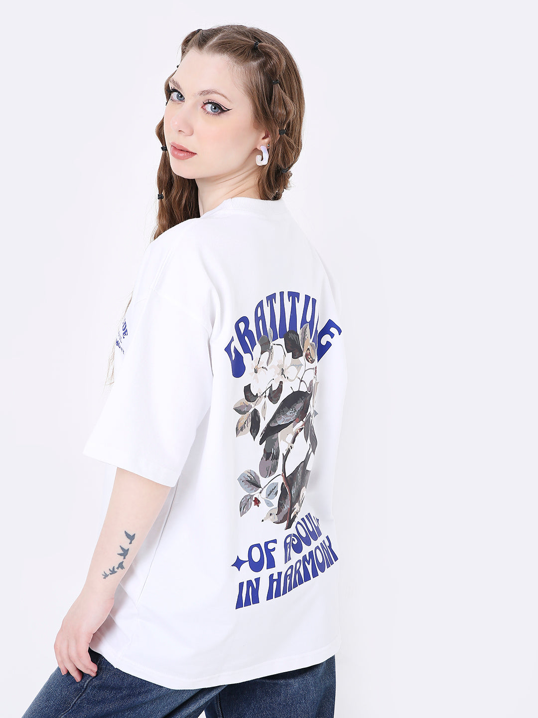 Oversize white T-shirt with blue graphic text and floral print on the back, model wearing size M.