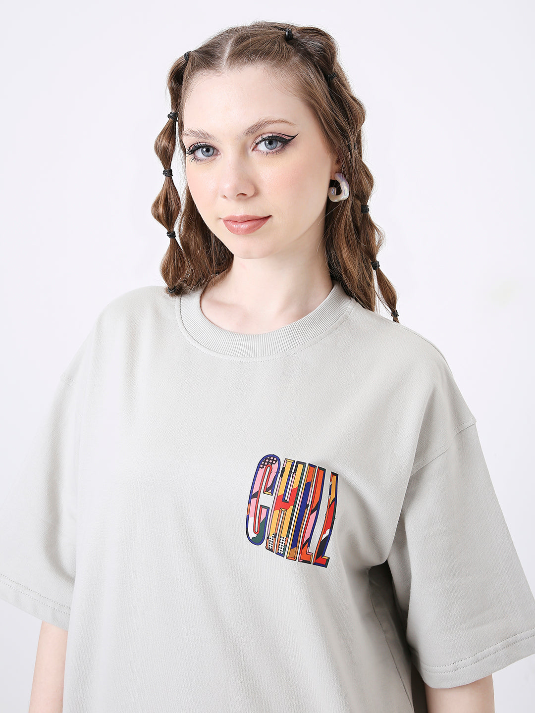 Light gray oversized t-shirt with colorful "CHILL" text printed on left chest pocket area.