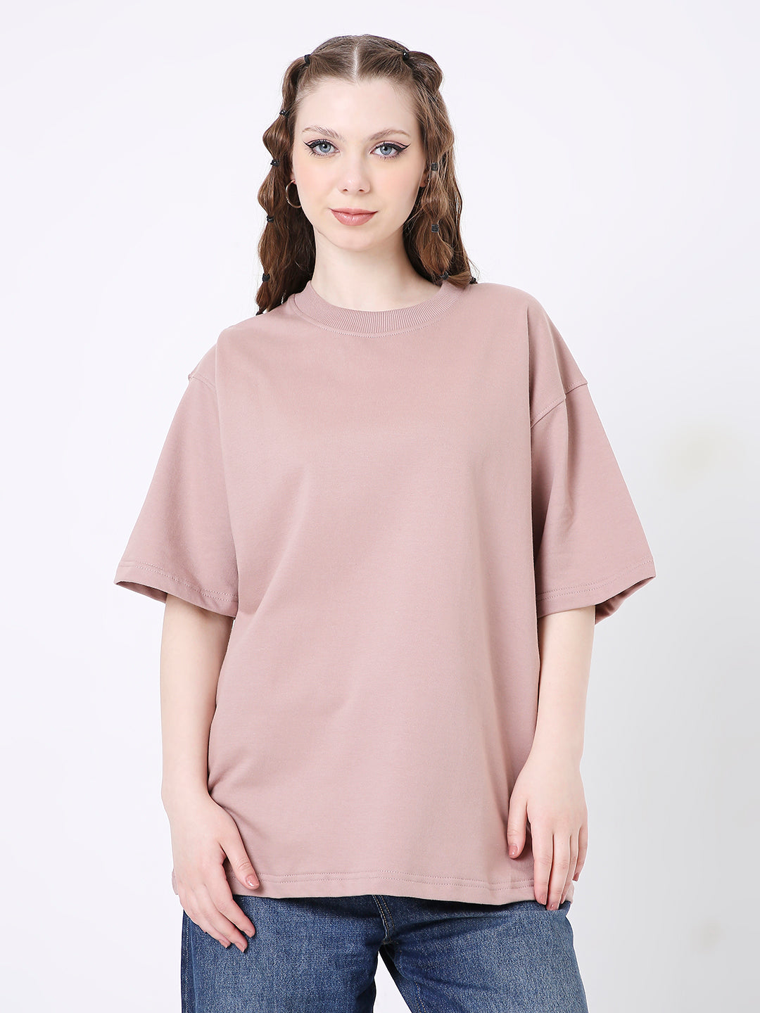 Oversize onion pink solid t-shirt with dropped shoulders on model wearing blue jeans.