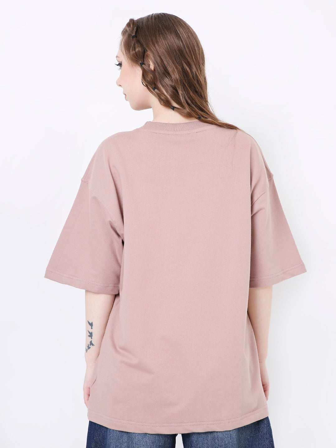 Oversize onion pink solid t-shirt with dropped shoulders and short sleeves on a model seen from the back.