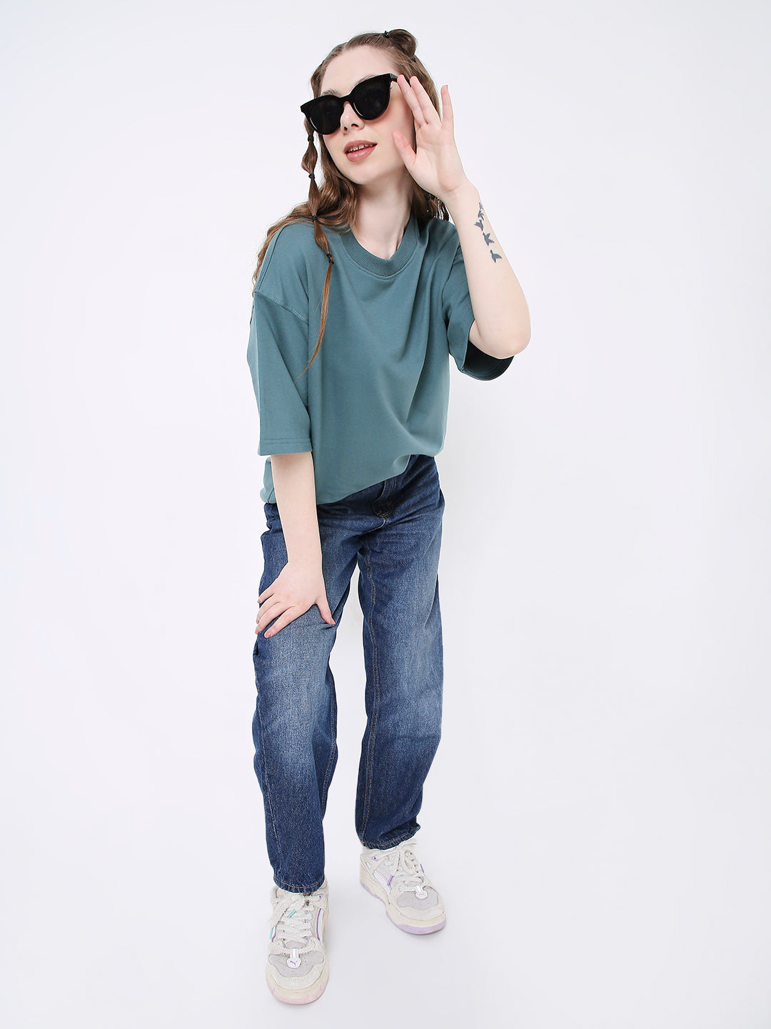 Oversize sapphire blue solid t-shirt with half sleeves worn with blue jeans and white sneakers.