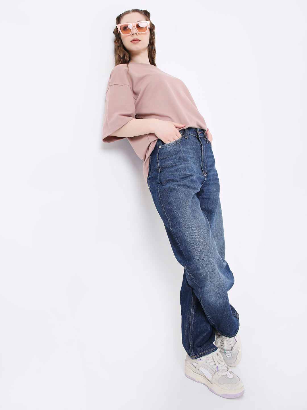 Oversize onion pink printed t-shirt with elbow-length sleeves paired with blue jeans and white sneakers.
