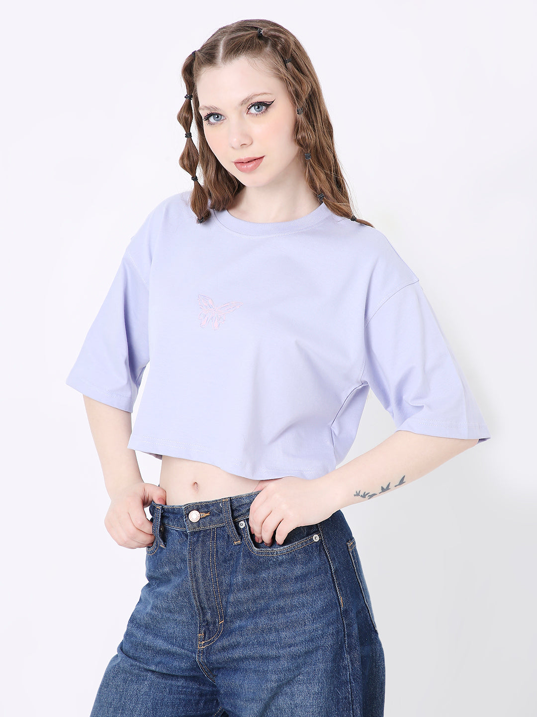 Lavender oversized crop top with subtle print, short sleeves, and relaxed fit paired with high-waisted jeans.