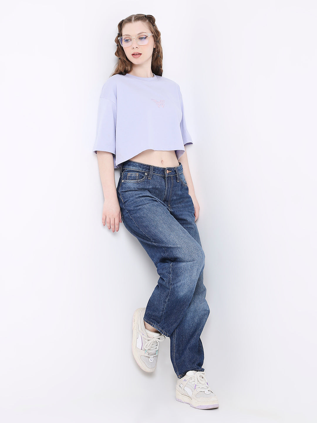 Oversize lavender crop top with subtle floral print, paired with loose blue jeans and white sneakers.