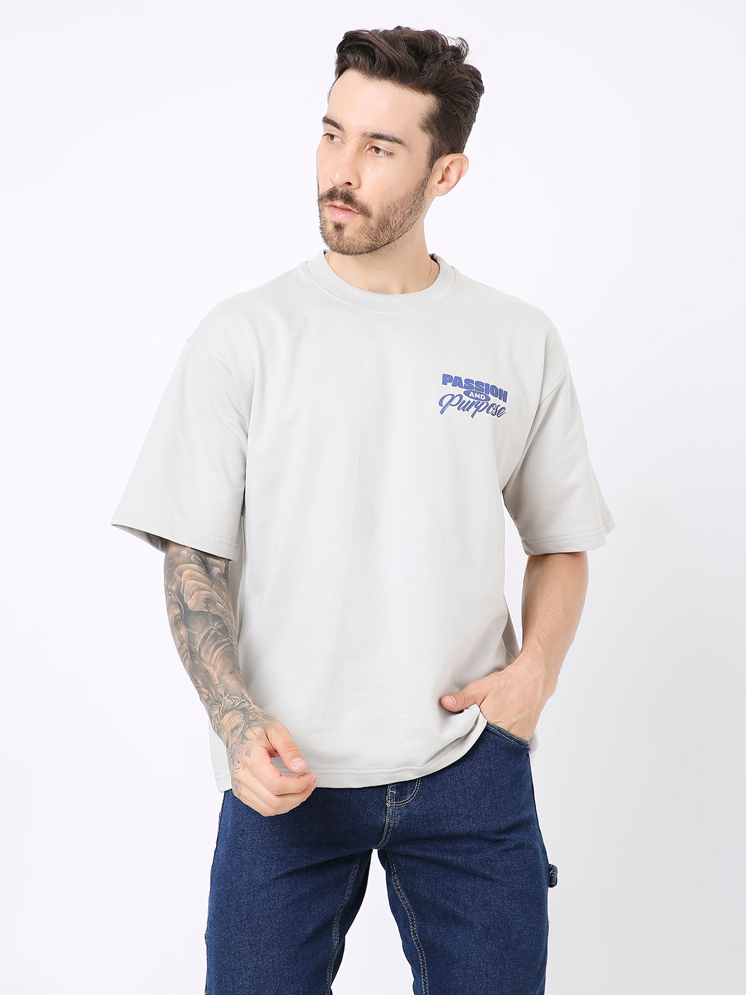 Light gray oversized t-shirt with blue "Pressing Play" text on chest, paired with dark blue pants.