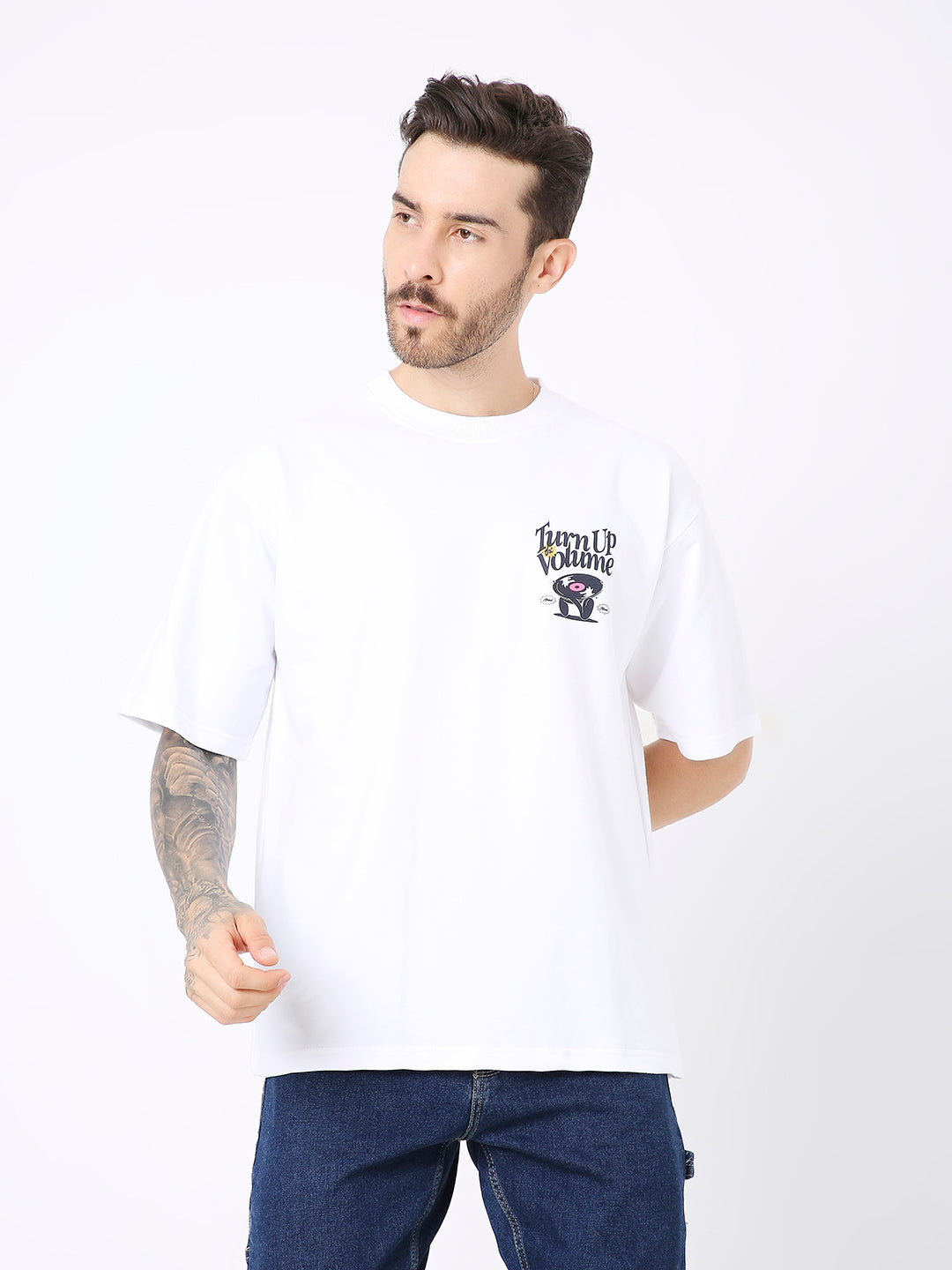 Oversize white cotton t-shirt with small black graphic print on chest, worn with blue jeans.