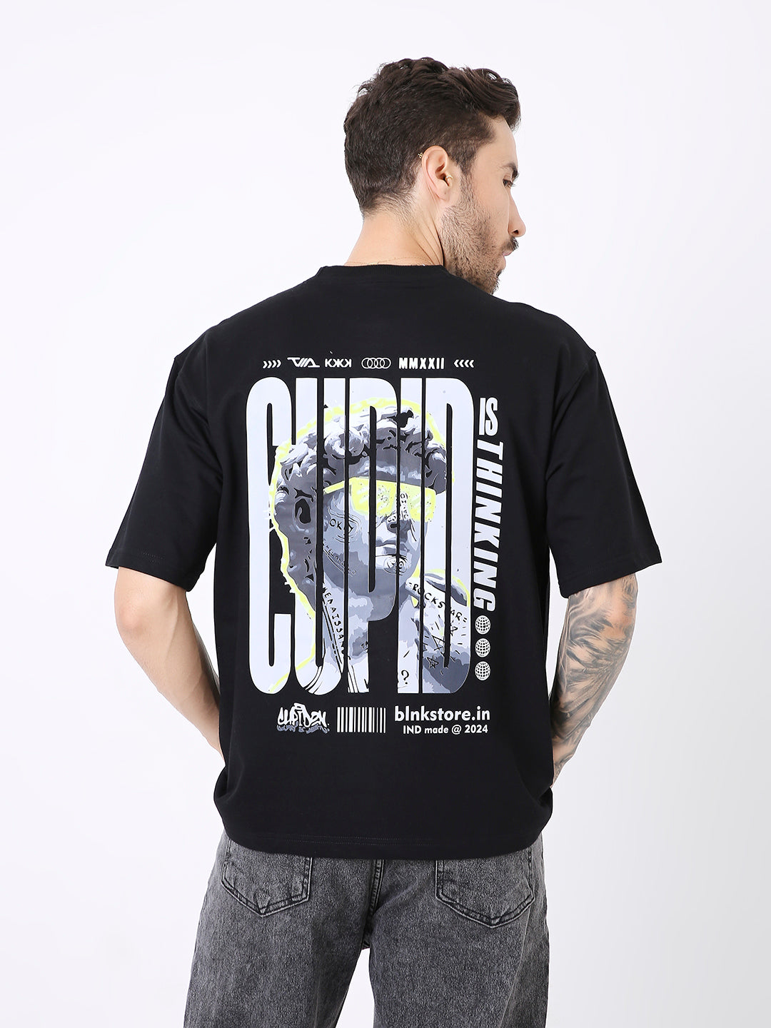 Oversize black t-shirt with large white and yellow graphic text print on back and short sleeves.