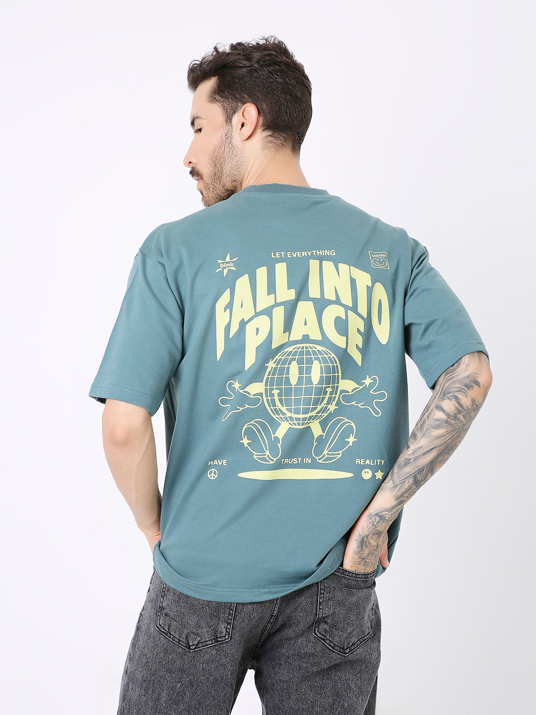 Oversized sapphire blue t-shirt with yellow "Fall Into Place" graphic and smiley face on back.