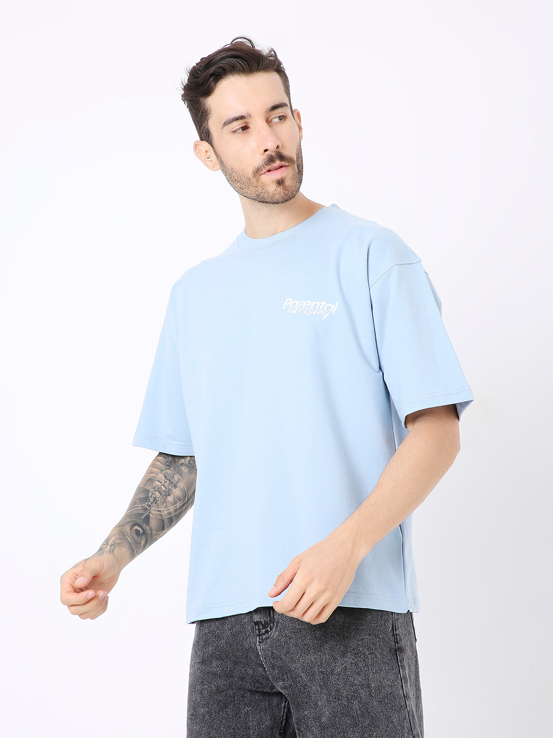 Oversize light blue cotton t-shirt with small white chest print and relaxed short sleeves.