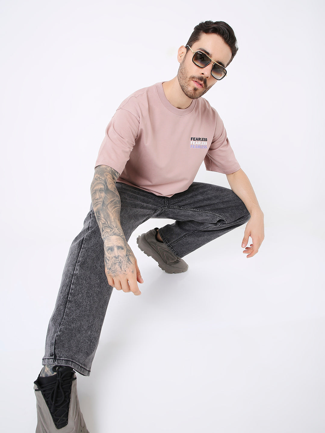 Oversize onion pink t-shirt with small chest print, worn with black washed jeans and black sneakers.