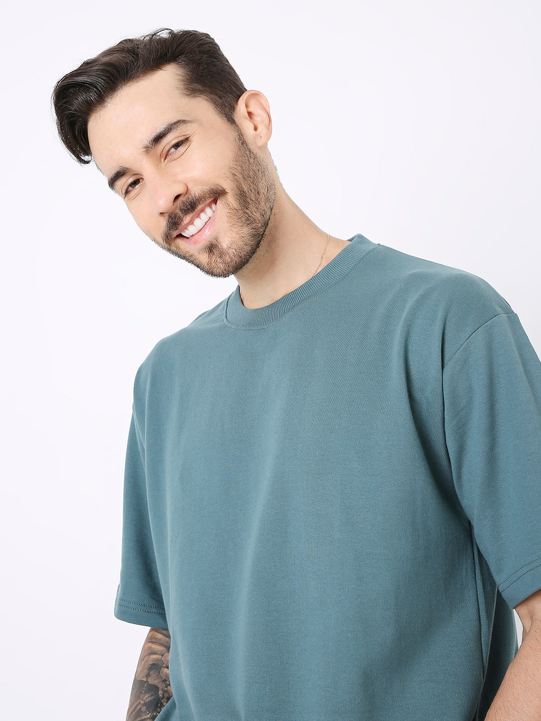 Oversize sapphire blue solid crew neck t-shirt with short sleeves on smiling male model.