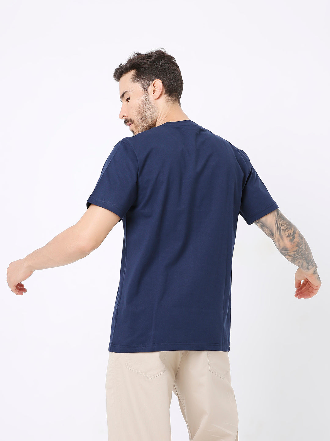 Navy blue relaxed fit t-shirt with short sleeves on male model facing backward.
