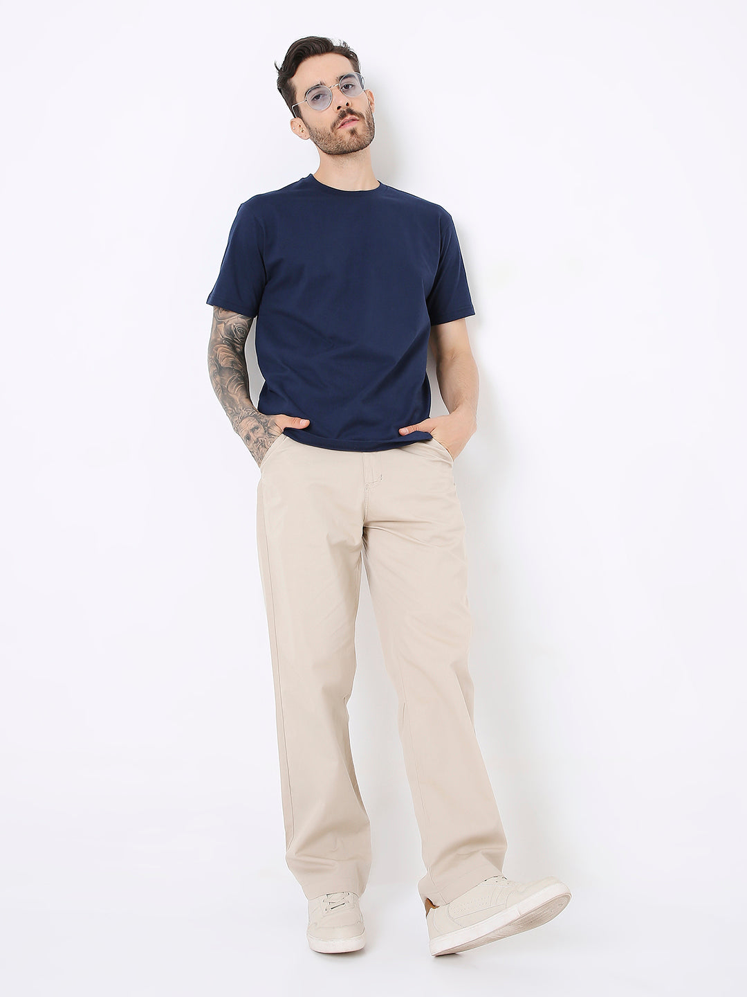 Navy blue relaxed fit T-shirt paired with beige wide-leg pants and white sneakers.