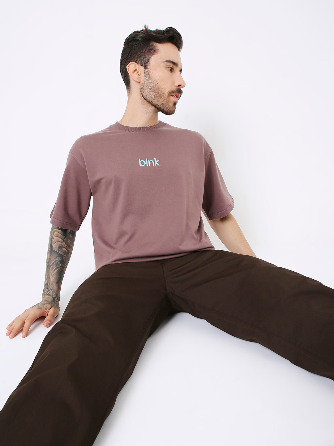 Oversize old rose t-shirt with small white "brnk." logo on chest, paired with dark brown pants.