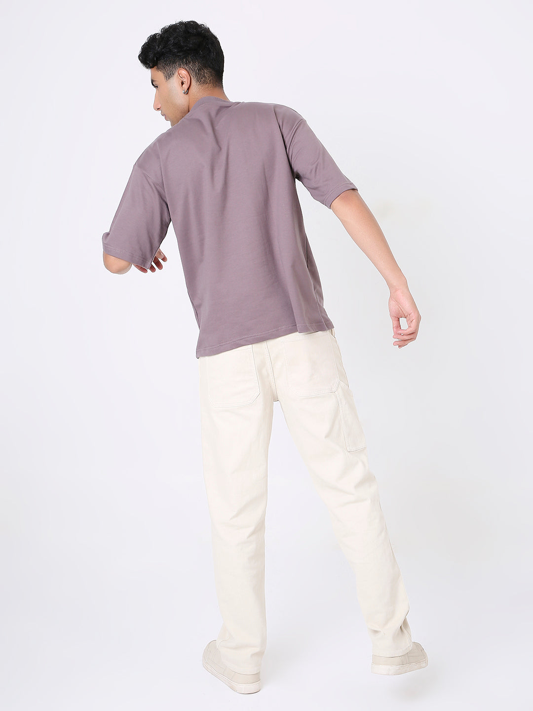 Oversized old rose short-sleeve t-shirt on male model with beige pants, back view.