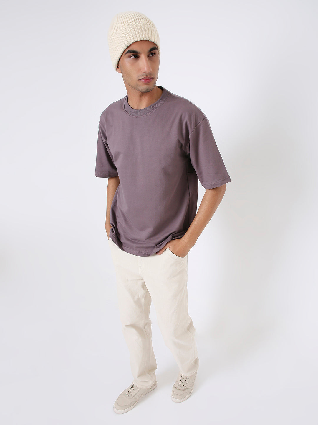 Oversized old rose short-sleeve t-shirt styled with cream pants and beige beanie on male model.