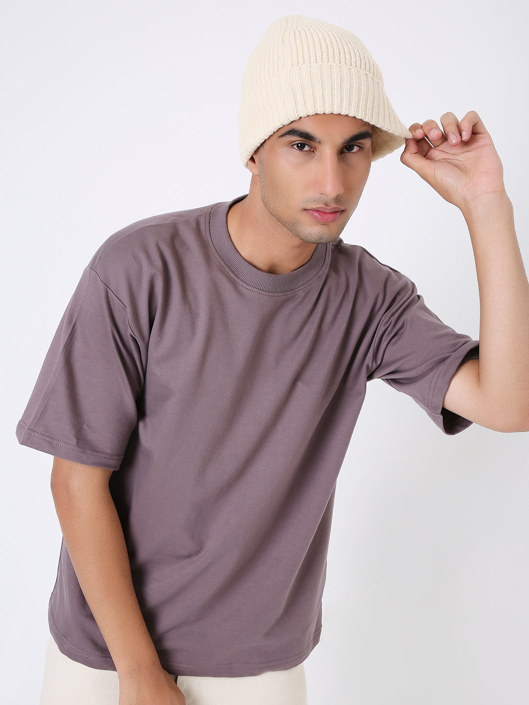 Oversized old rose solid t-shirt with crew neck and short sleeves worn by male model with beige knit beanie.