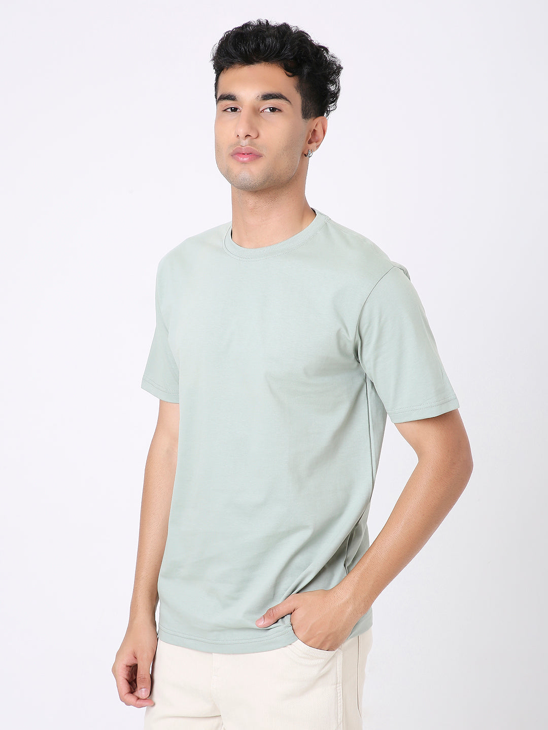 Relaxed fit sage green t-shirt with short sleeves and crew neck worn by male model.
