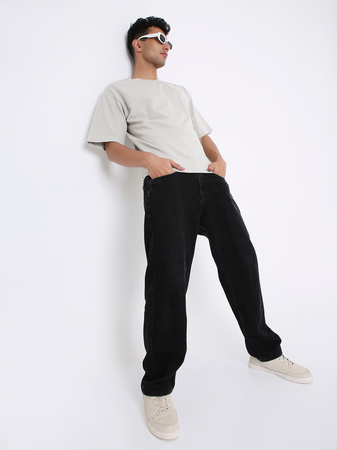 Light gray oversized short-sleeve t-shirt paired with loose black pants and white sneakers.