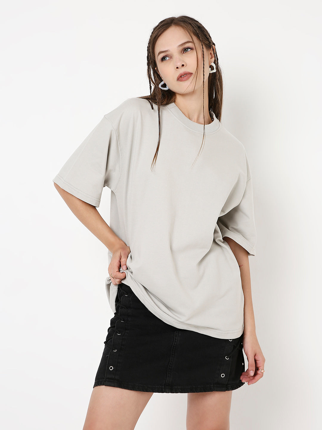Oversize light gray solid t-shirt with dropped shoulders styled with a black mini skirt.