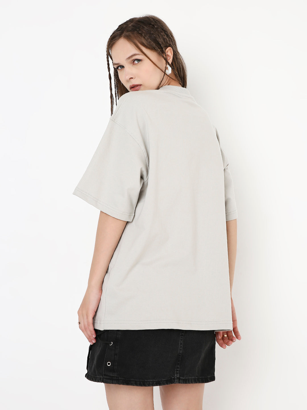 Oversize solid light gray T-shirt with dropped sleeves paired with black buttoned skirt.