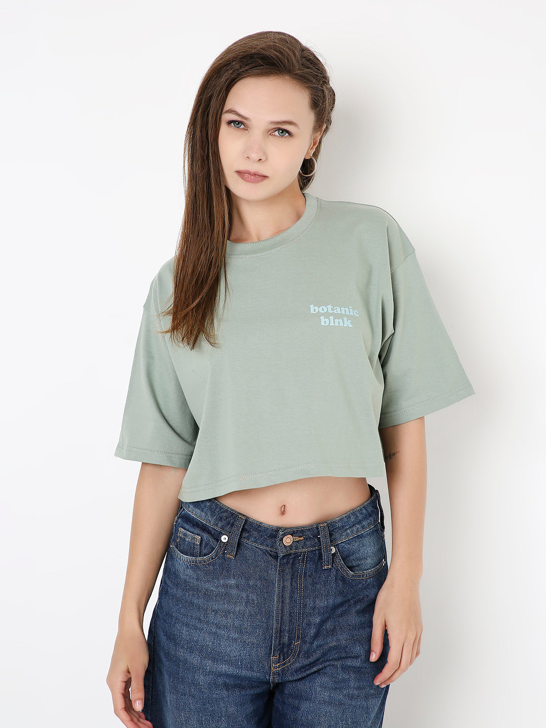 Oversize sage green cropped T-shirt with short sleeves and small white chest print.