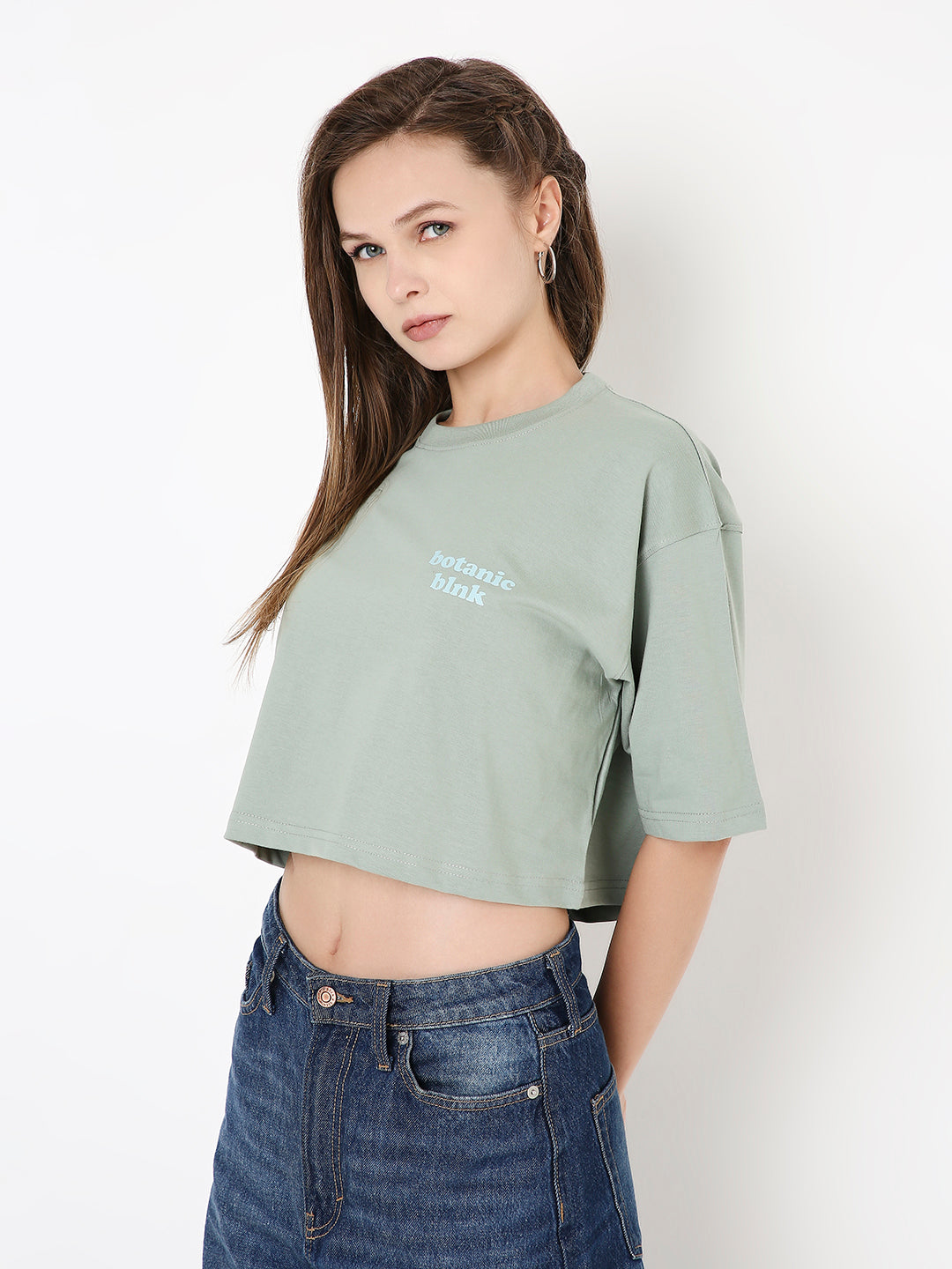 Sage green oversized cropped top with short sleeves and small white chest print.