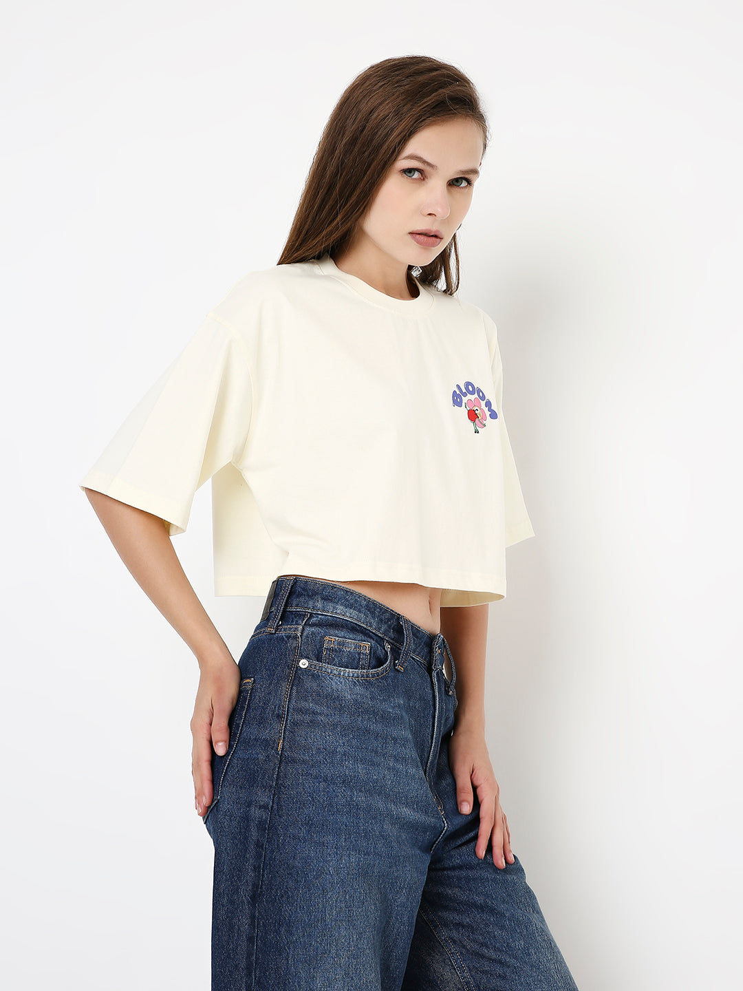 Off-white oversized crop top with colorful printed design on chest and short wide sleeves.