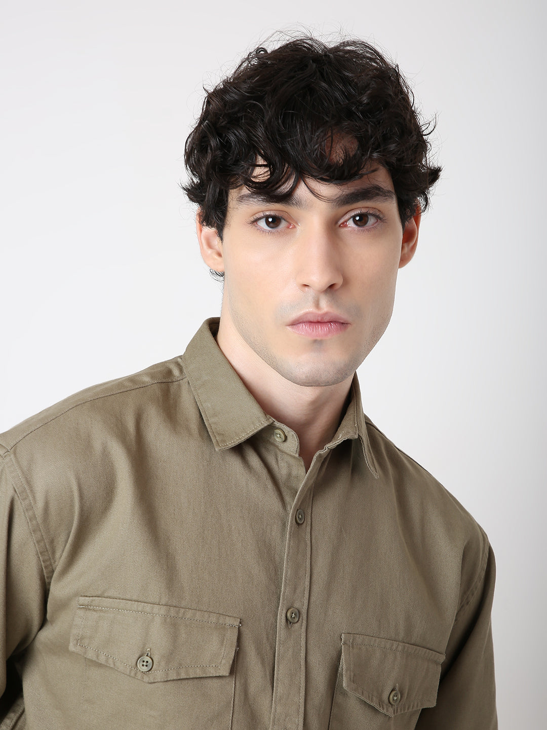 Man wearing a brown shirt against a white background