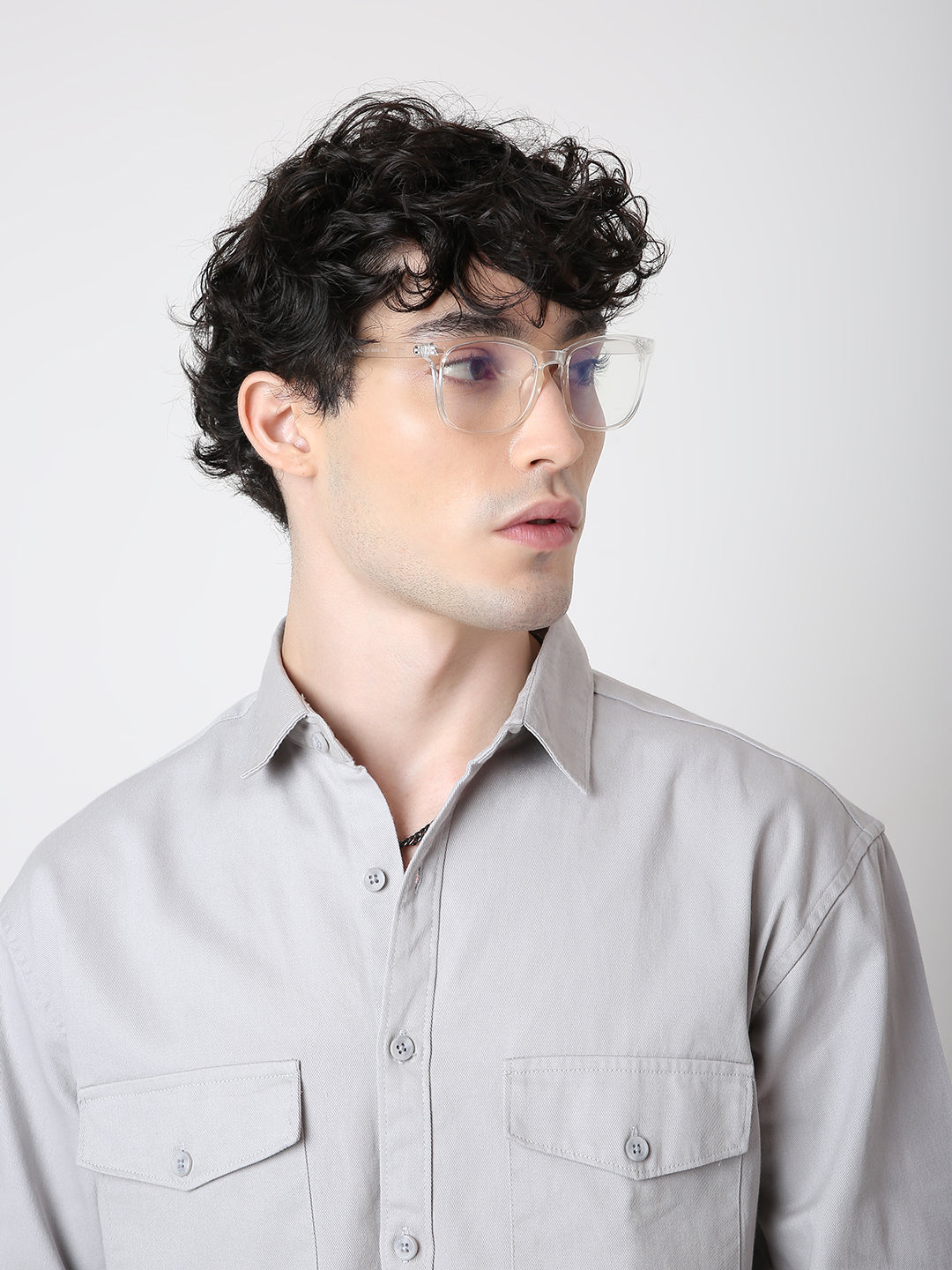 Man wearing a light gray shirt against a plain background