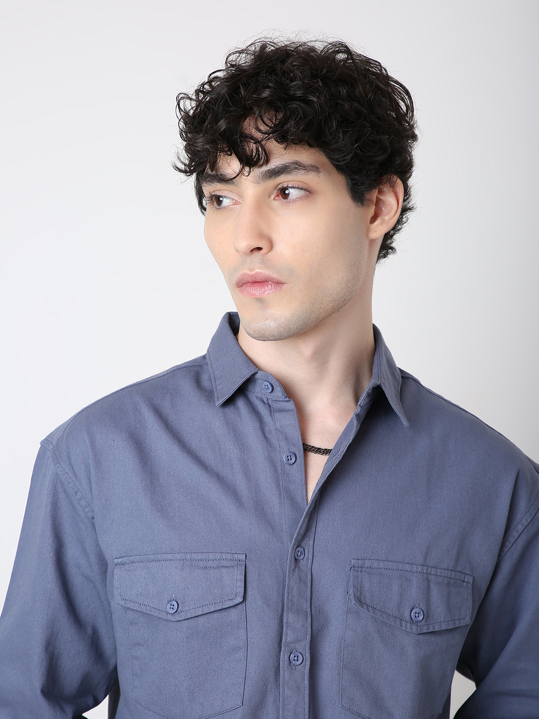 Man wearing a blue shirt against a white background