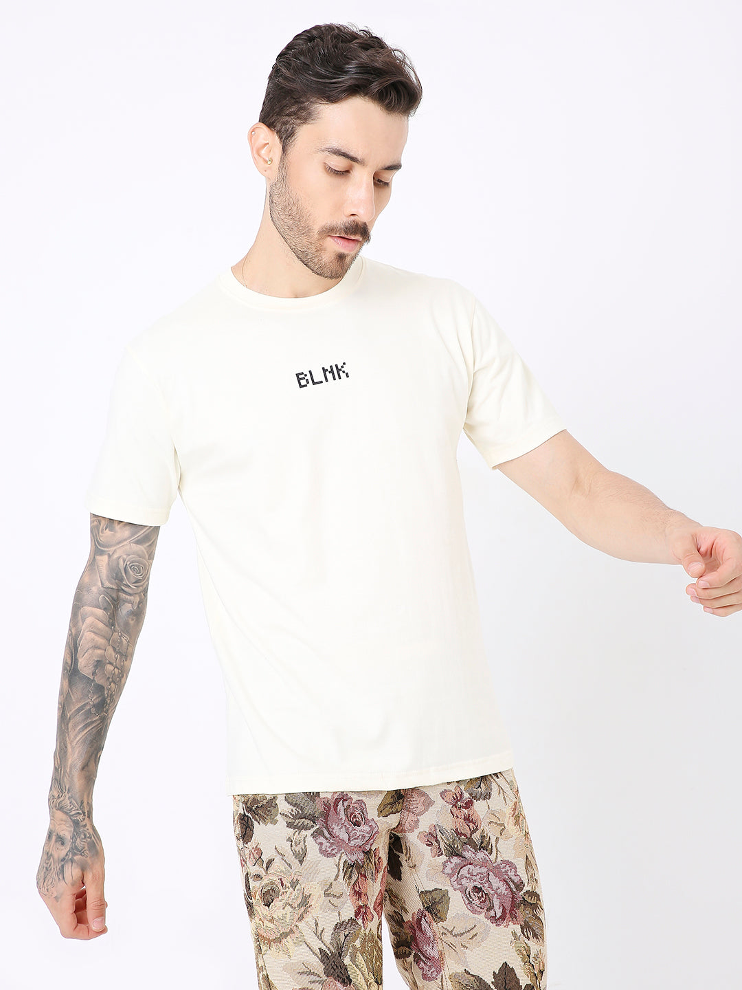 Off-white relaxed fit T-shirt with small black "BLVKT" text on chest, worn by model.