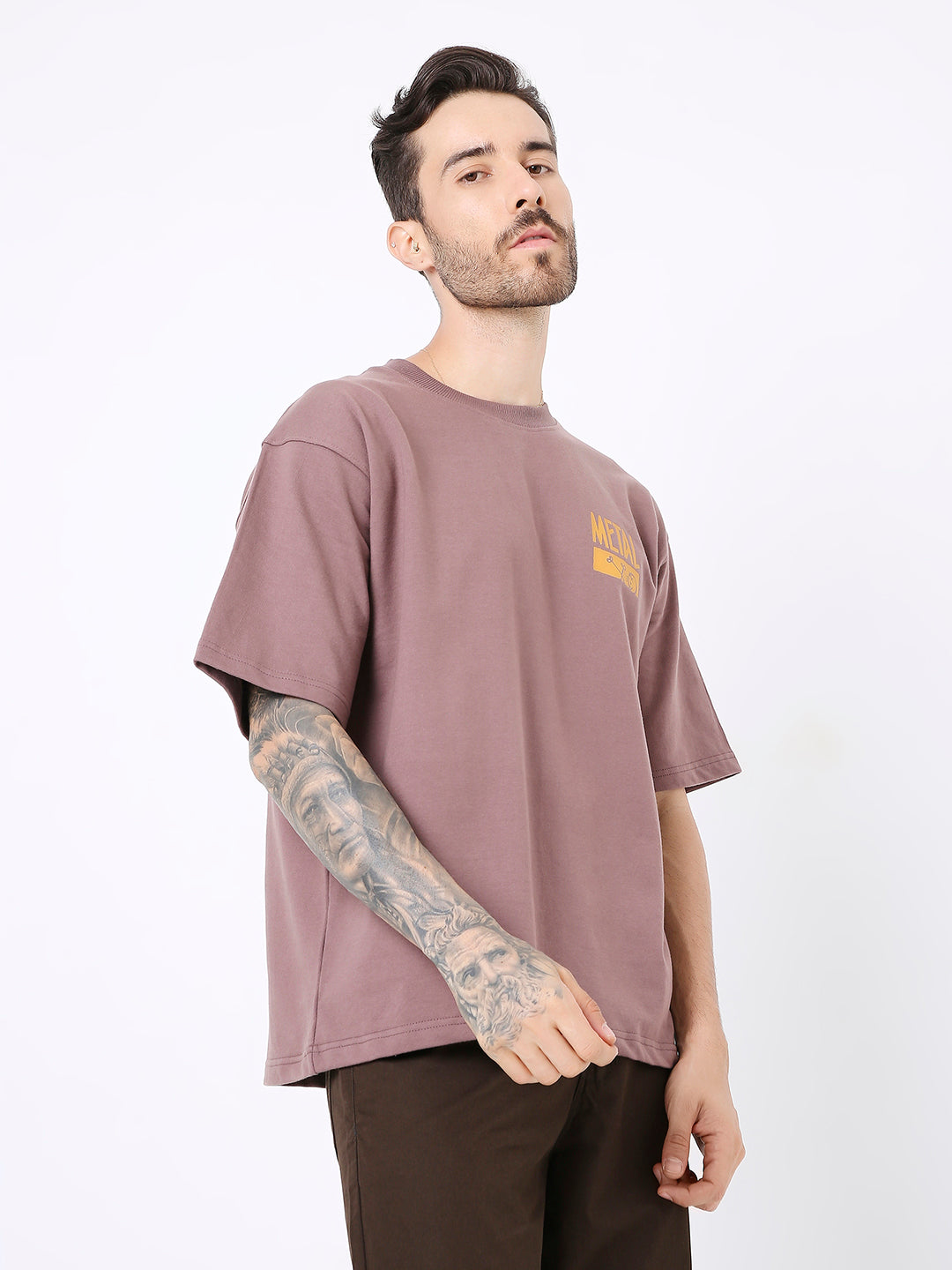 Oversize old rose t-shirt with orange print on chest, worn by tattooed male model.